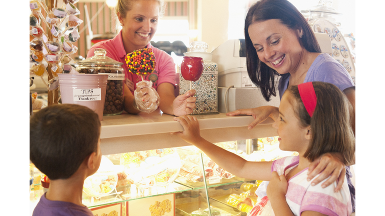 Waitress handing candy apple to young girl