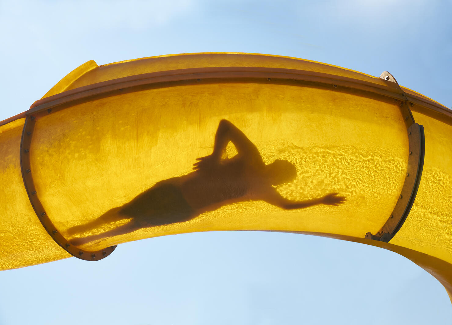 Silhouette of person sliding down water slide