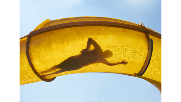 Silhouette of person sliding down water slide