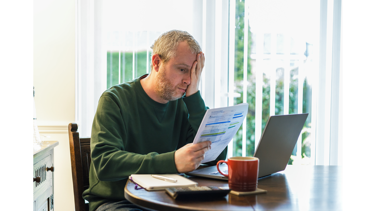 Worried man checking bills at home