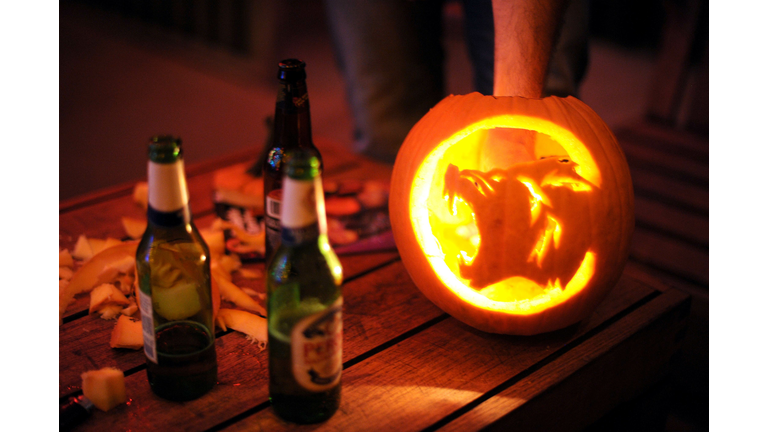 A warewolf carved on a pumpkin next to t