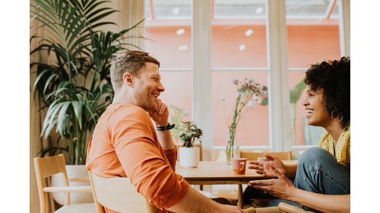A man and a woman look relaxed as they have a lighthearted conversation.