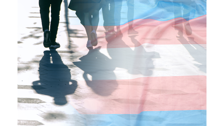 Transgender flag, shadows and silhouettes of people on a road, conceptual picture about anonymous Transgender and Gay Lesbian in the World