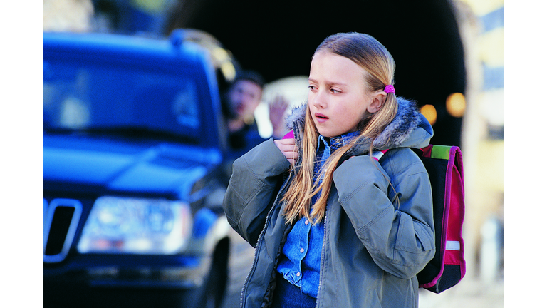 Man in a Car Waving to an Apprehensive Girl Standing in a City Street