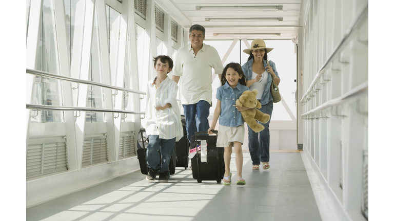 Hispanic family walking through airport