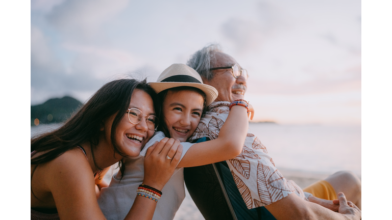 Grandfather and granddaughters having fun on beach