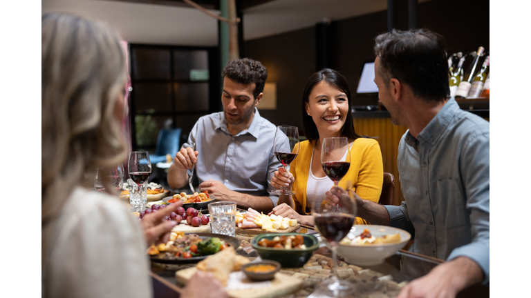 Happy woman having dinner with a group of friends