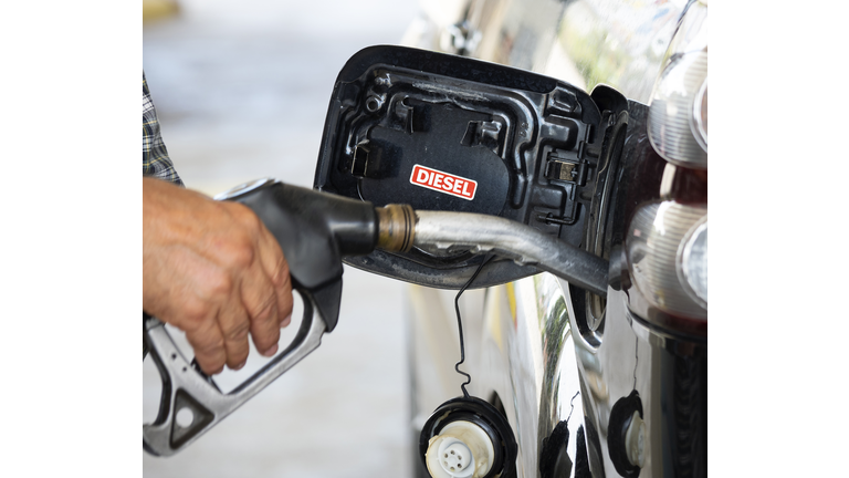 Hand of a men from with a hose of fuel refueling a diesel vehicle with self serve pump and hose. Spain.