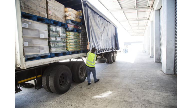 Worker loading a lorry at a large warehouse
