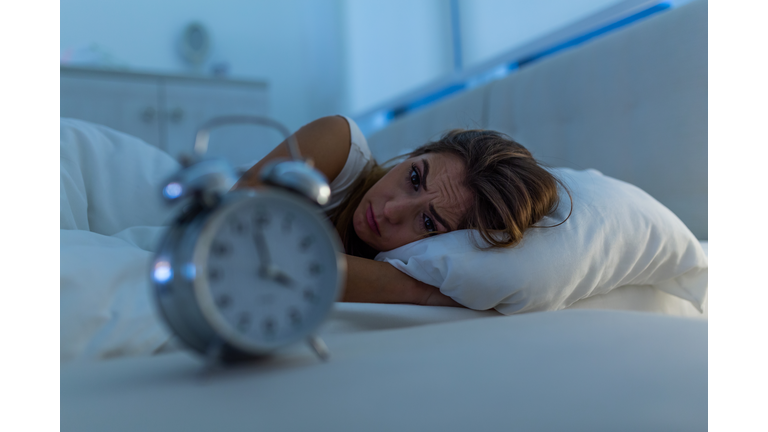 Woman with insomnia lying in bed with open eyes. Girl in bed suffering insomnia and sleep disorder thinking about his problem at night