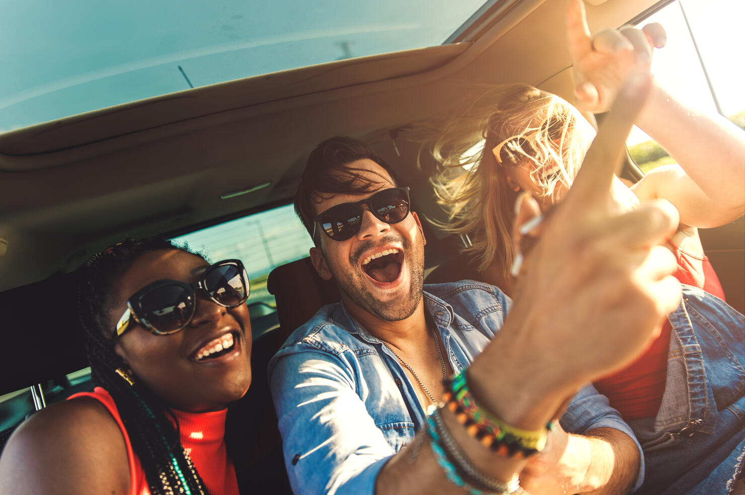 Three best friends enjoying traveling in the car.