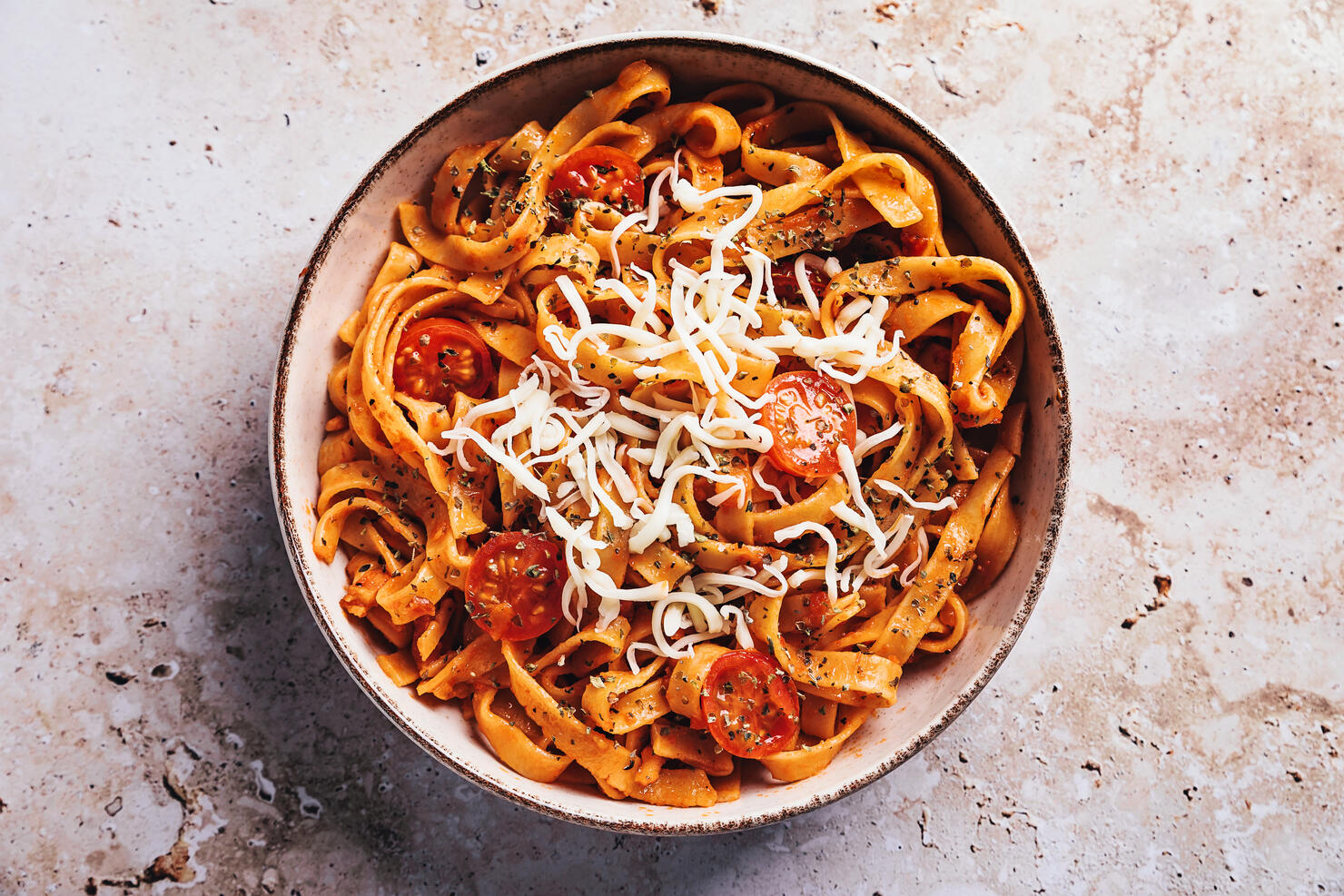 Tagliatelle with tomato sauce on stone background