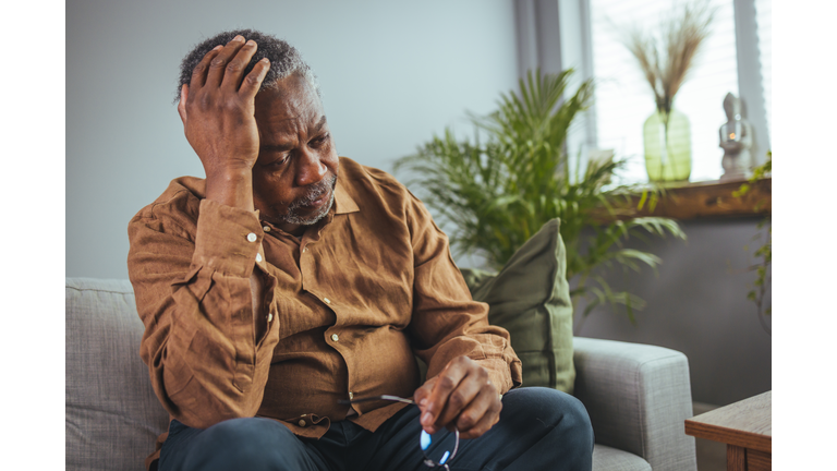 Frustrated unhealthy senior mature man touching head