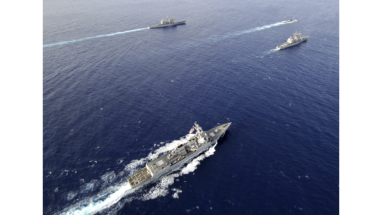 Aerial view of a naval fleet transiting the Pacific Ocean.