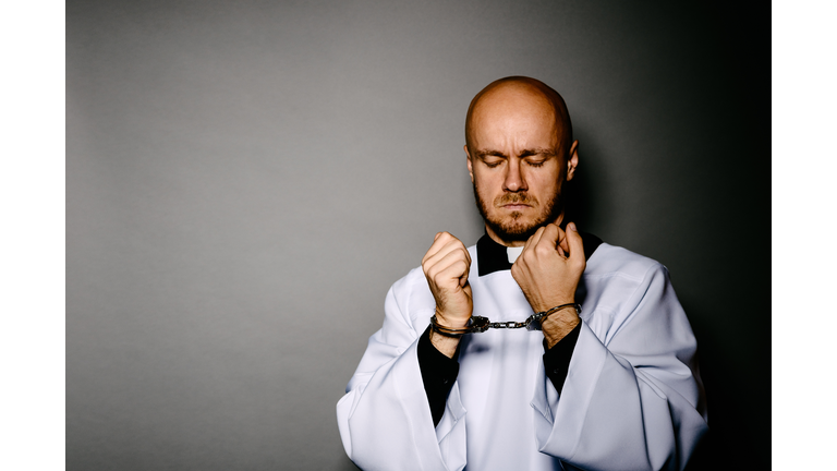 Handcuffed Catholic priest