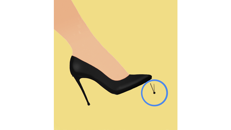 Foot of woman wearing high heels stepping on clock