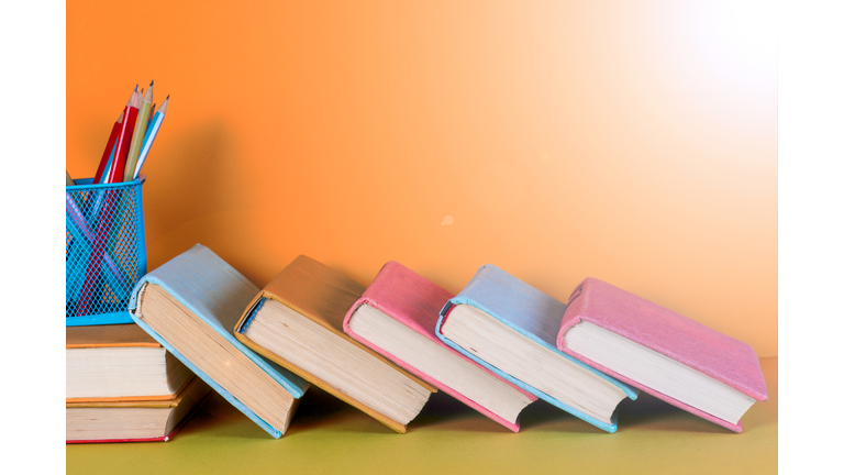 Open book, hardback books on bright colorful background.