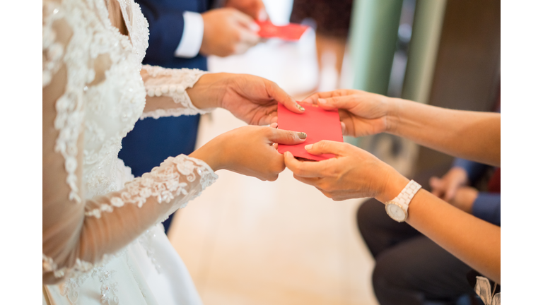 Elders giving red packet to newlywed couple