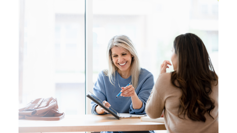 Female financial advisor reviews documents on digital tablet