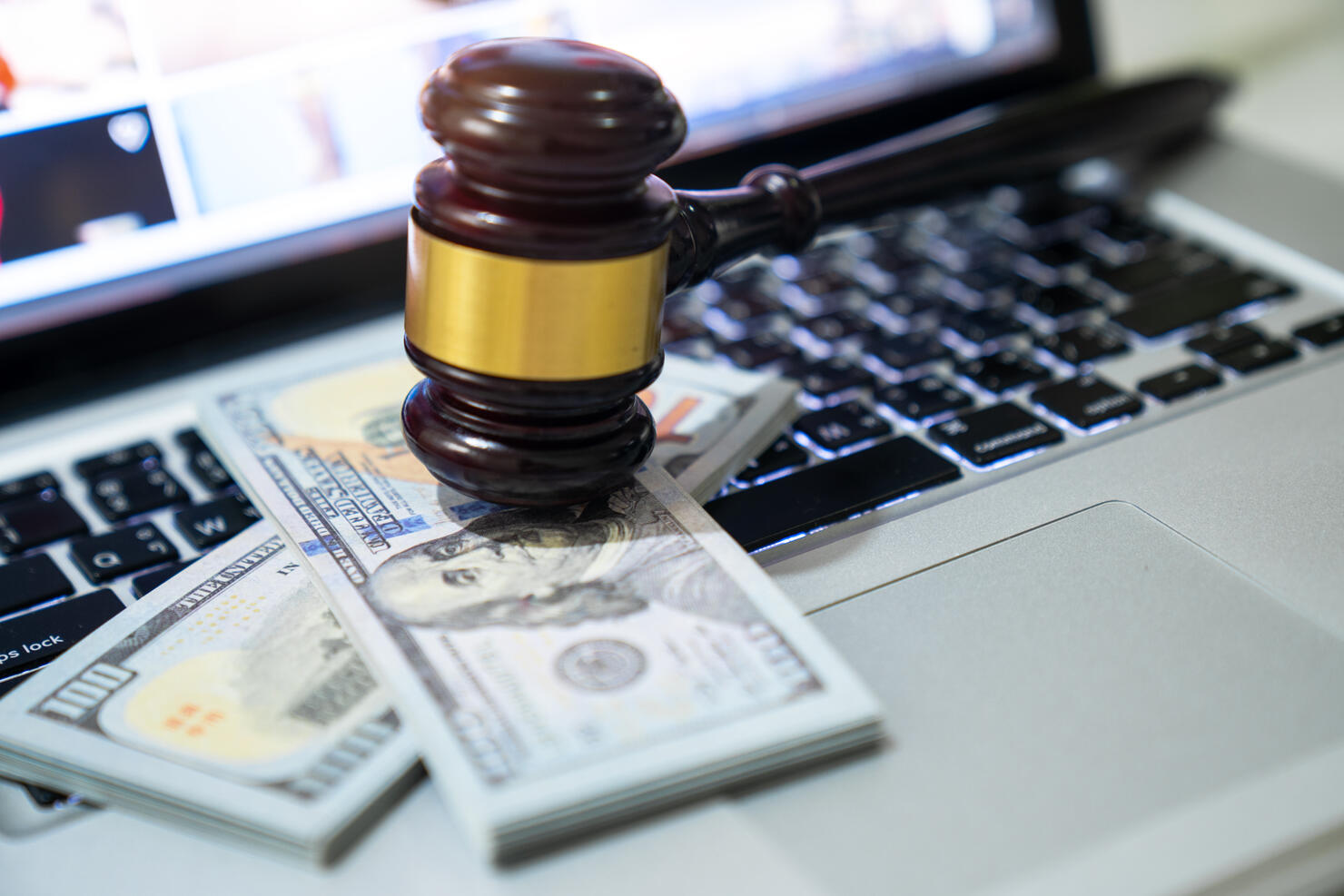 US paper currency on Laptop and gavel,Money with a hammer