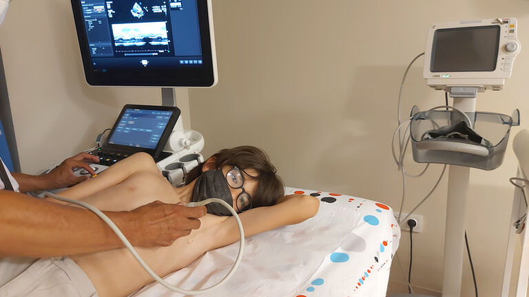 Doctor examining a child patient's heart by using an ultrasound equipment.