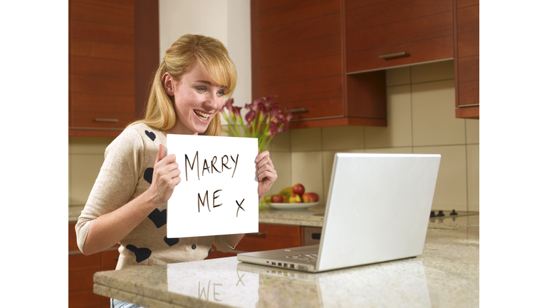 Young woman on the internet with marry me sign