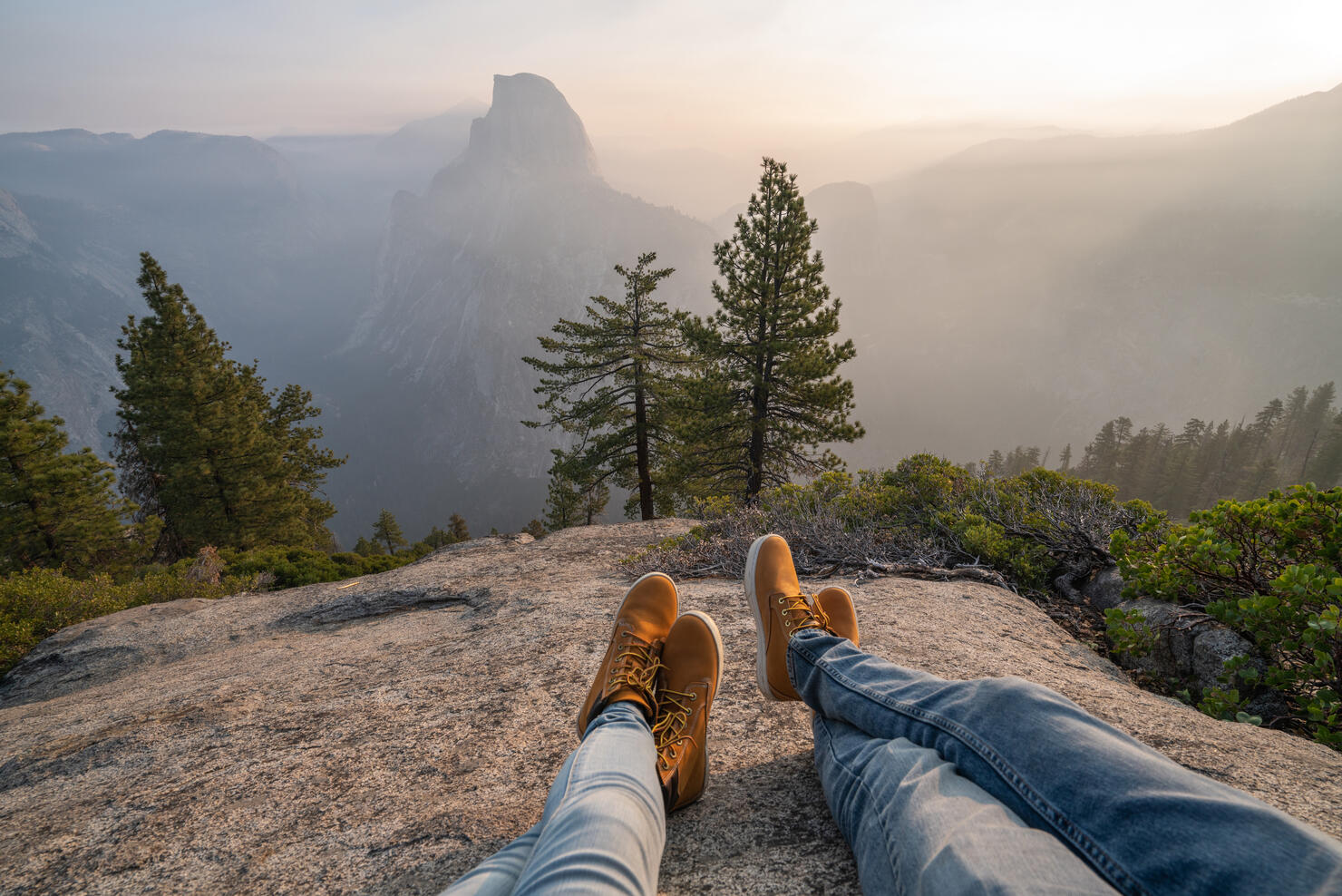 Personal perspective of couple relaxing on top of Yosemite valley; feet view