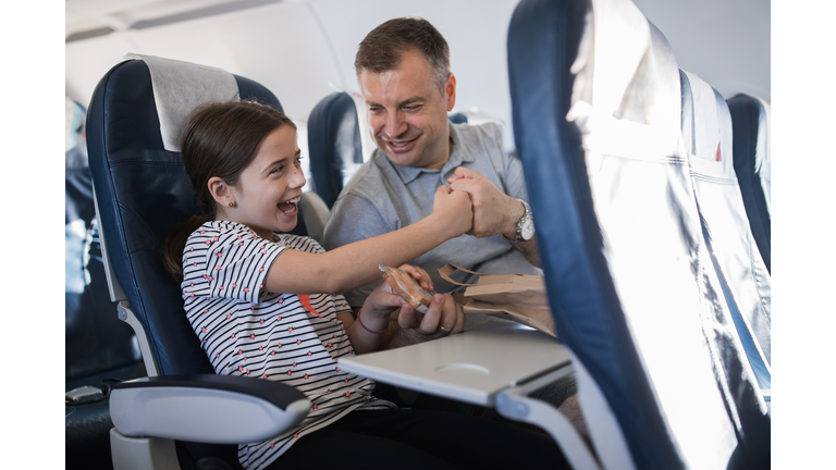 Happy father and daughter having a fist bump when sharing sandwich