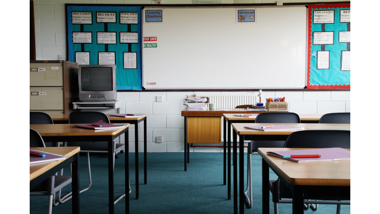 Empty school classroom, exercise books and pens on table