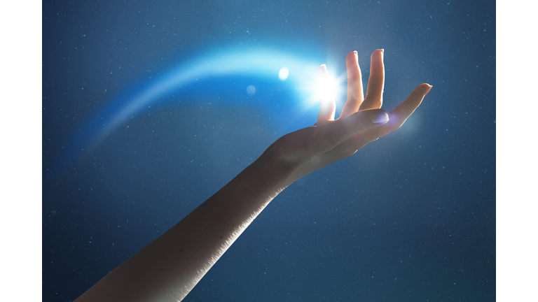 Hand holding a glowing shooting star
