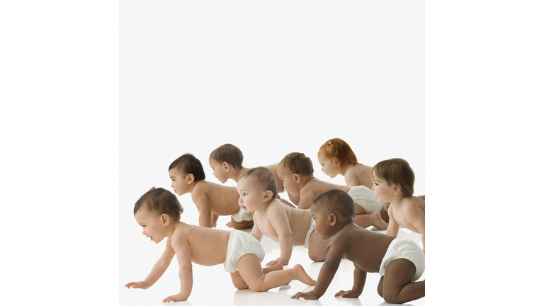 Studio shot of babies in diapers crawling