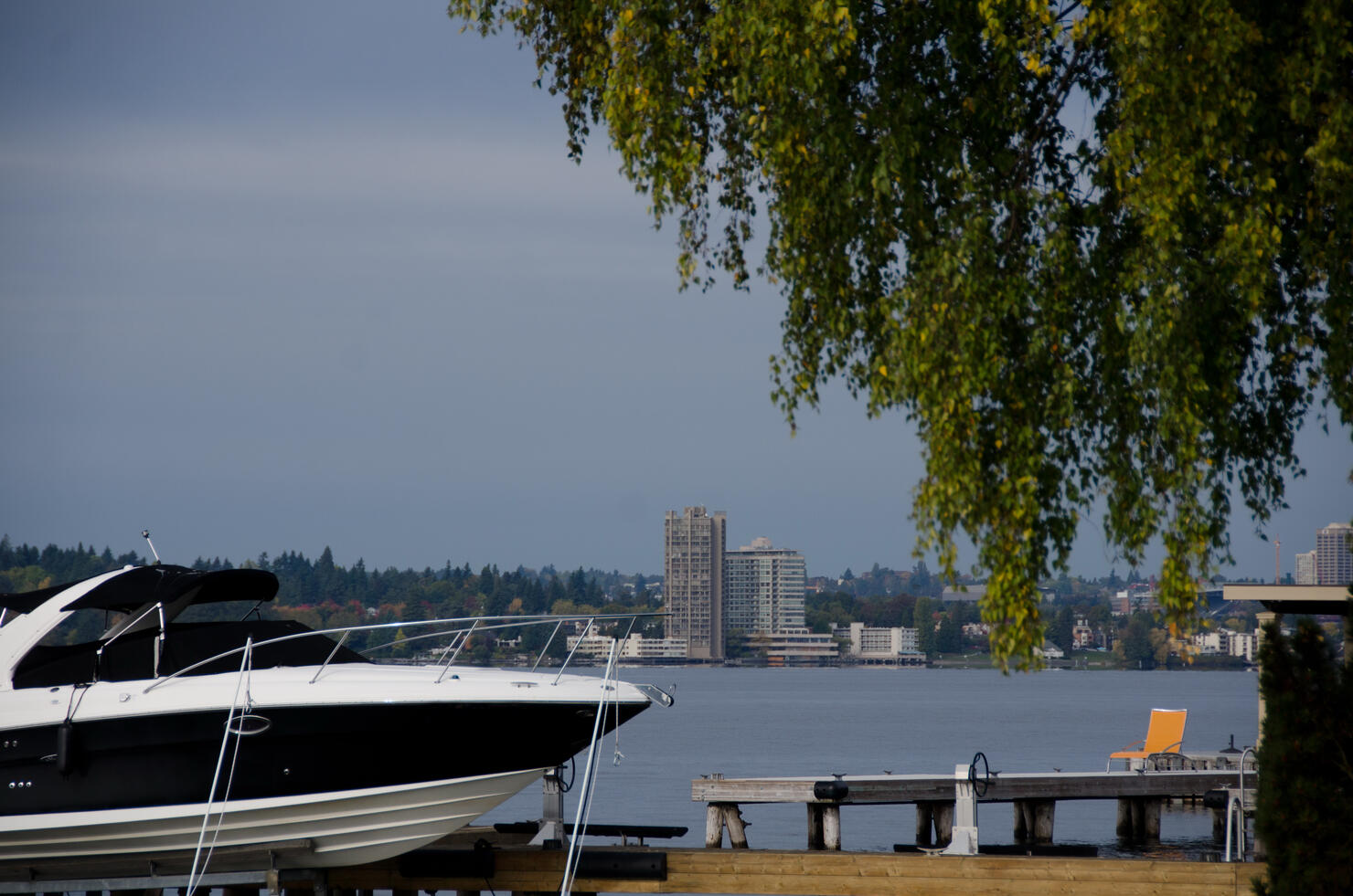 Motor boat and orange beach chair near Washington lake surf line in Medina beach park, Bellevue, Washington