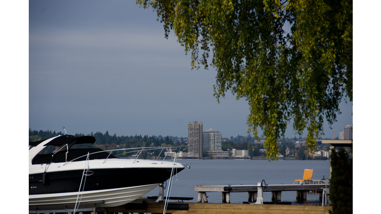 Motor boat and orange beach chair near Washington lake surf line in Medina beach park, Bellevue, Washington