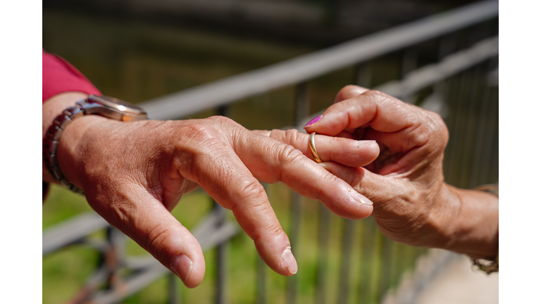 Hands close-up, ring and senior couple divorce. Woman takes off wedding ring to her husband. Removing engagement ring