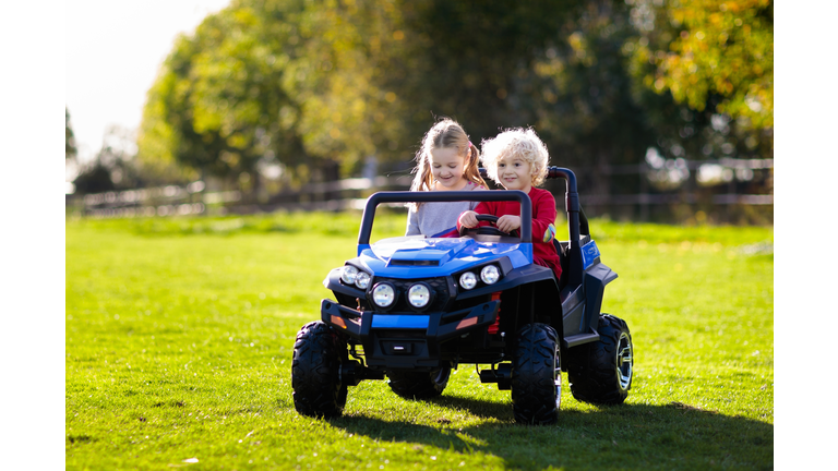 Kids driving electric toy car. Outdoor toys.