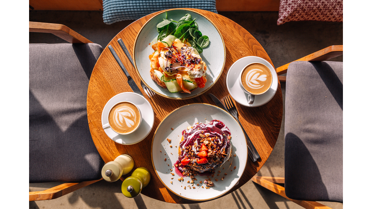 Brunch with sweet pancakes and Eggs Benedict with salmon served in restaurant