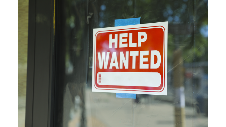 Help wanted sign in front of store front