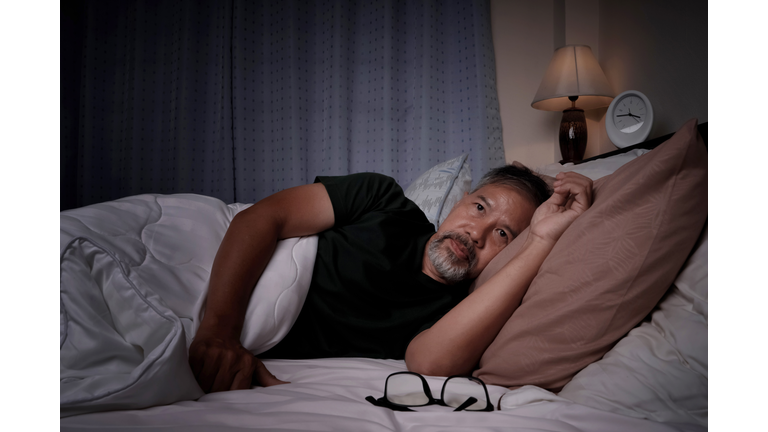 depressed old man and stressed lying in bed from insomnia