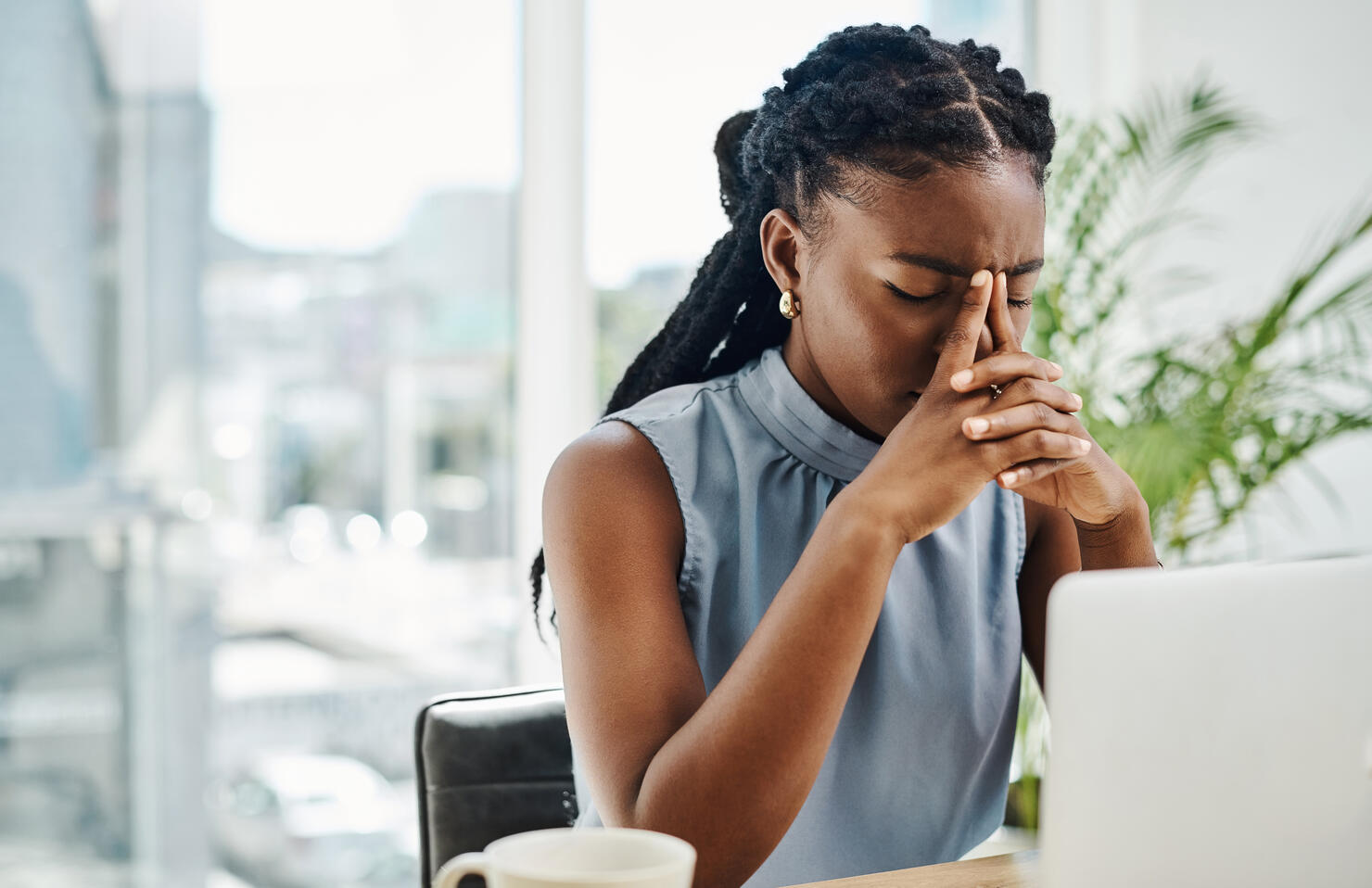 Stressed black businesswoman working on a laptop in an office alone