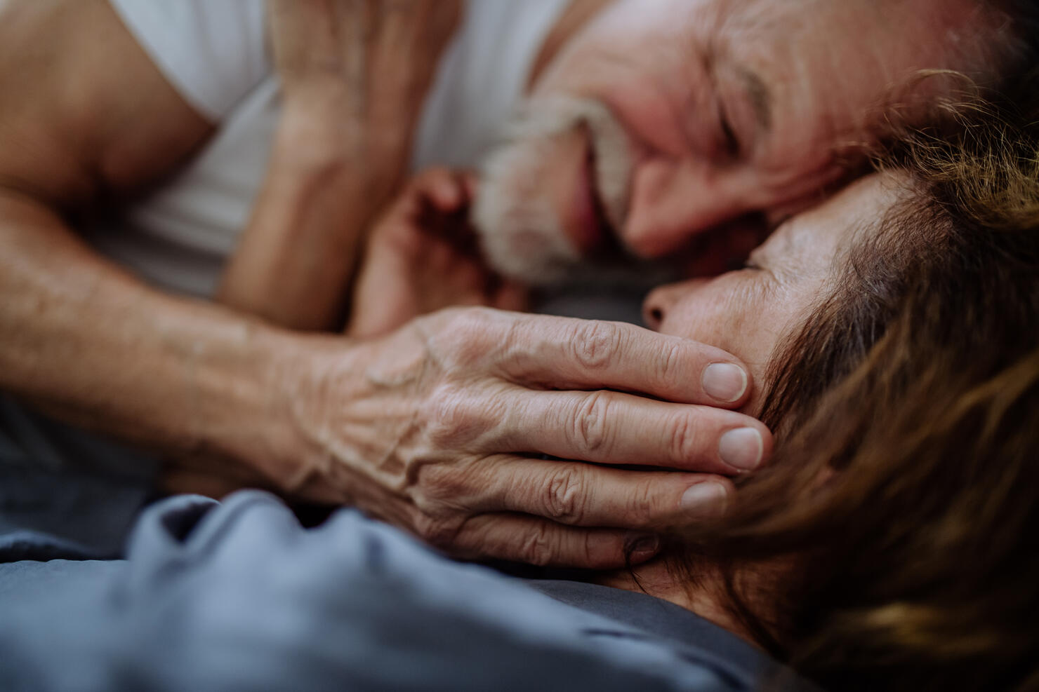 Close-up of senior couple lying together in bed. Concept of long lasting love.