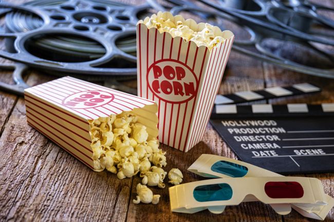 Bags of Popcorn Clapper Board and Movie Reels on Retro Wood Background