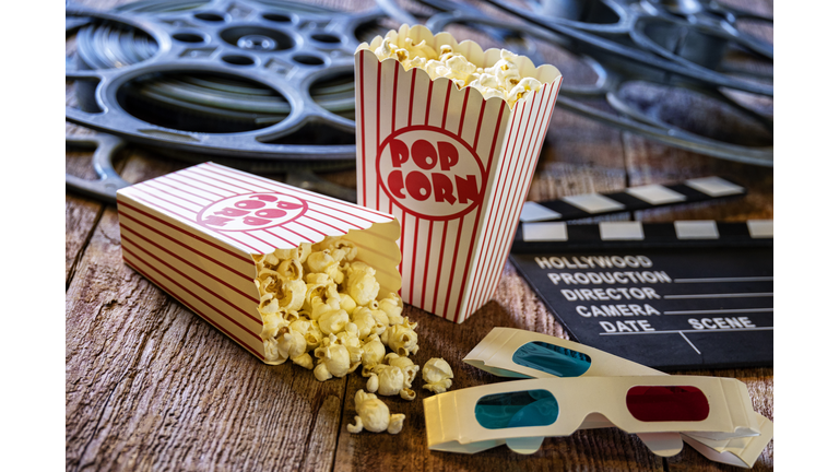 Bags of Popcorn Clapper Board and Movie Reels on Retro Wood Background