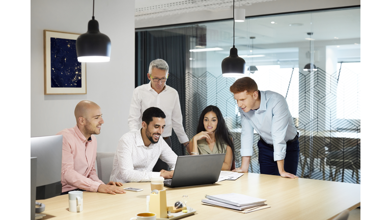 Confident professionals are discussing over laptop