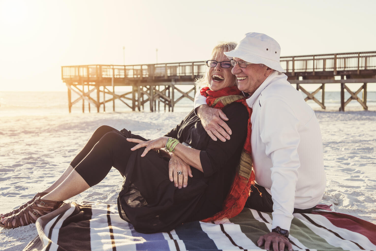Tender moment for senior couple on the beach at sunset.