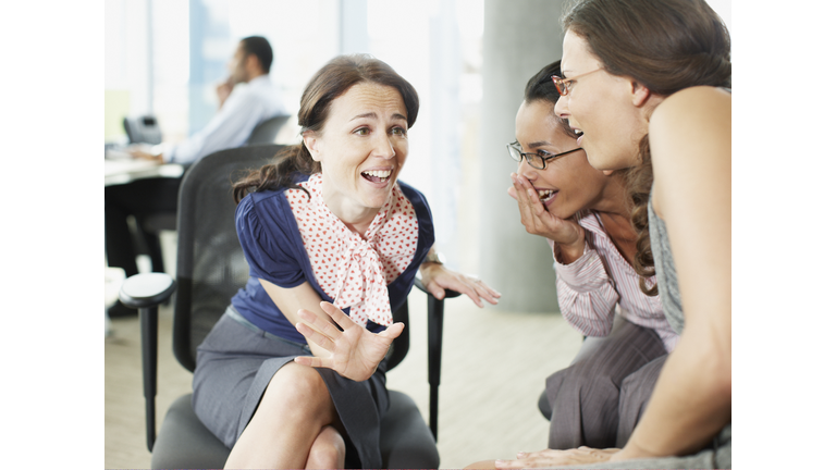 Businesswomen gossiping in office