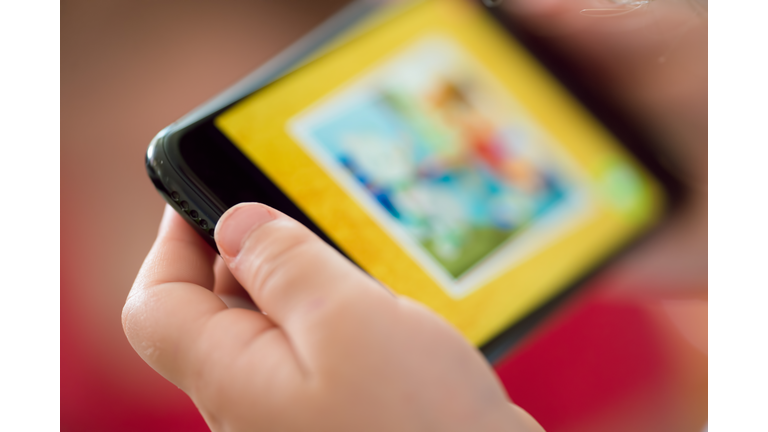 Multi-racial girl getting screen time watching content on a cell phone