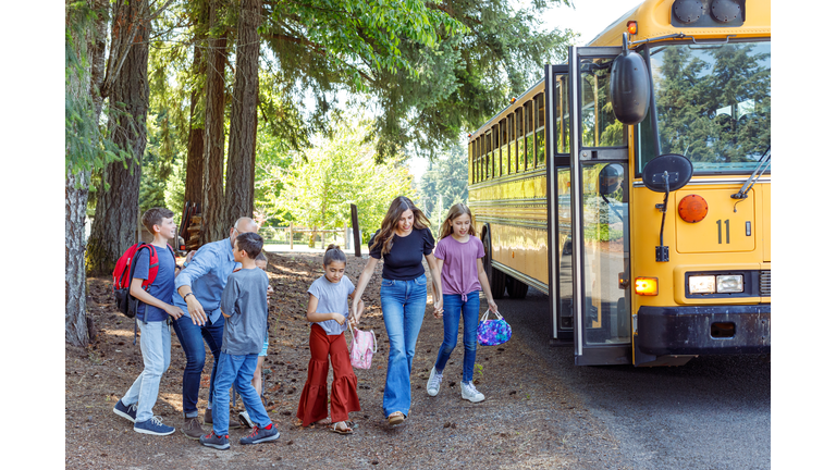 Parents greeting children at bus stop after school