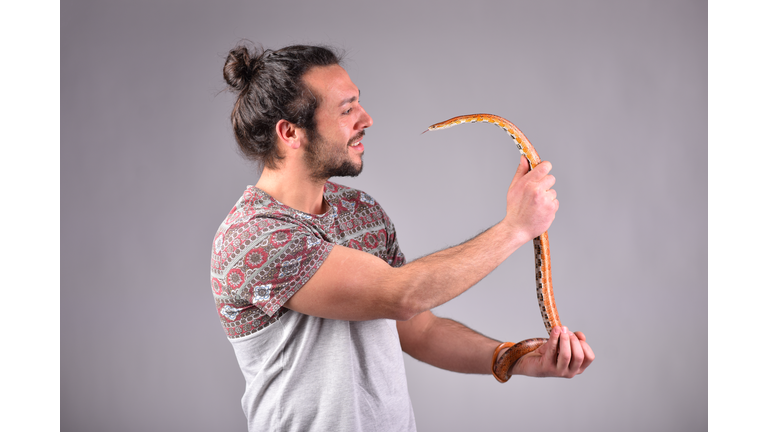 Corn snake and fearless man looking at each other