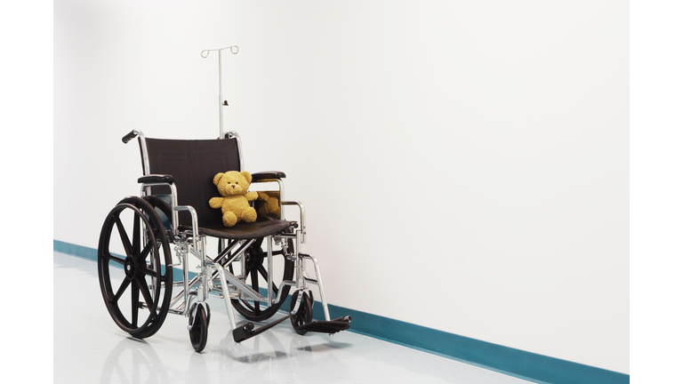 Wheelchair with teddy bear in hospital corridor