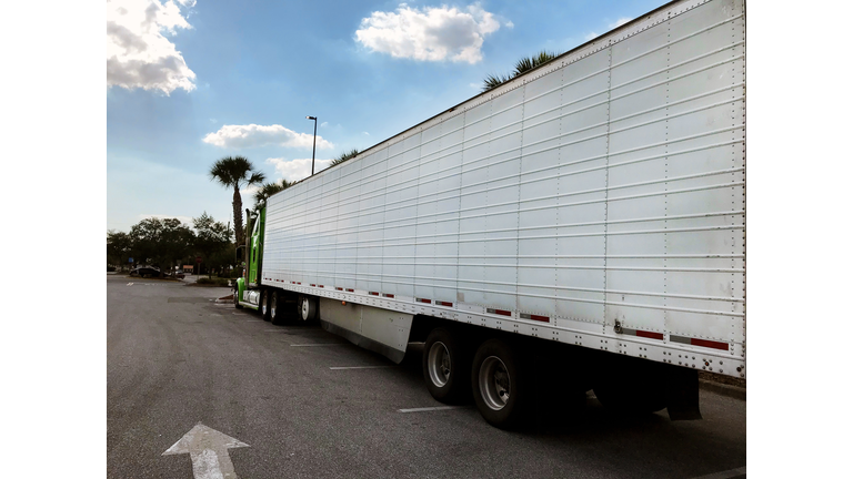 Close up side view of long freight truck on asphalt road